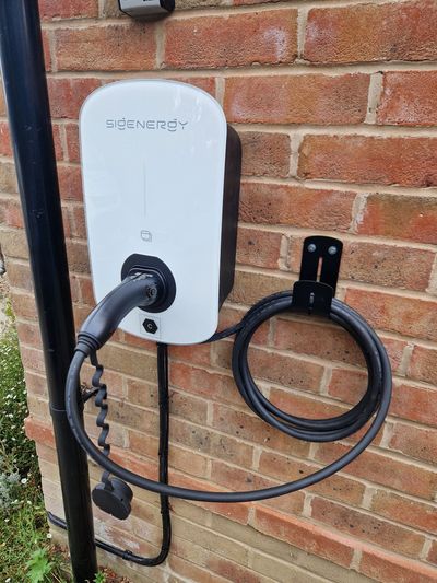 Sigenergy tethered EV charger installed on a brick wall